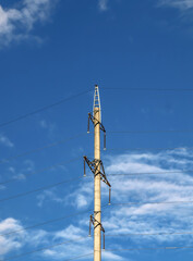 Obraz premium reinforced concrete electricity pole transmits electricity against the sky in a mountainous area