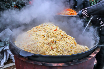 Cooking pilaf in a cauldron outdoors