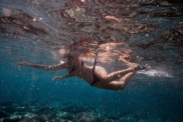 Young woman snorkeling underwater in the sea.