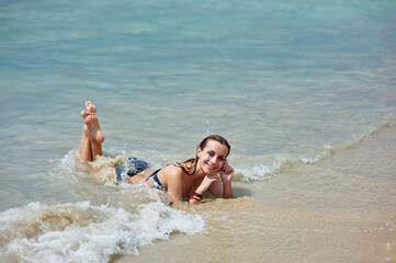 Vacation on the sea. Happy young woman enjoying suntan on the sand beach.