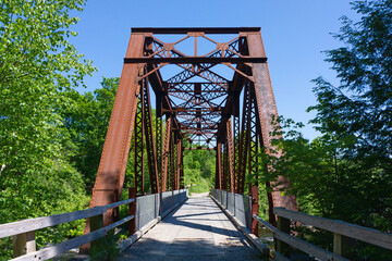 View of an old steel bridge over a stream in Maine.