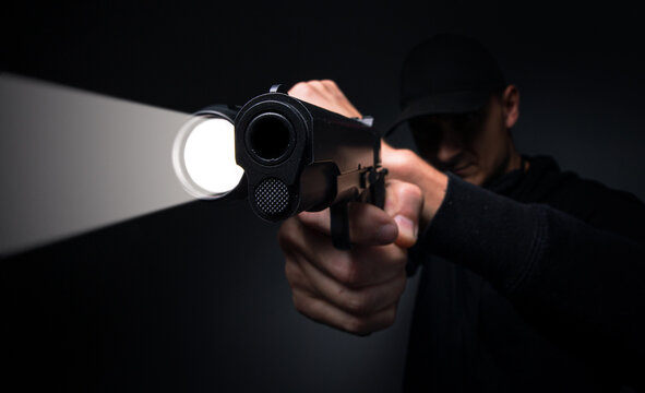 Professional security guard or policeman with flashlight and gun in dark room