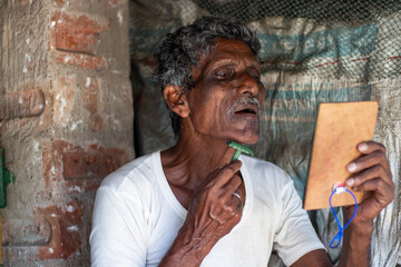 Indian rural man shaving at home