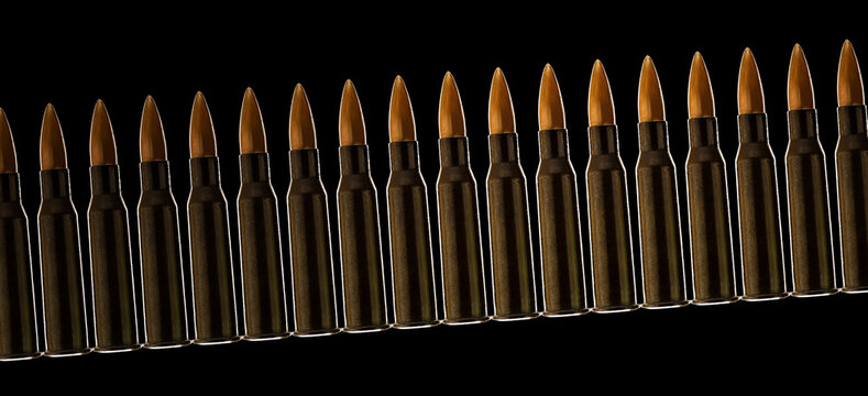 Rifle bullet long cartridge on black background. Pattern of shiny gun case cartridges.