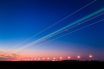 Lichtspuren eines am Flughafen landenen Flugzeugs zum späten Abend durch Langzeitbelichtung.