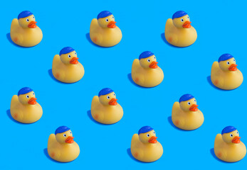 Obraz na płótnie Canvas Yellow toy duckling for bathing on the blue background. Flat lay. Pattern.