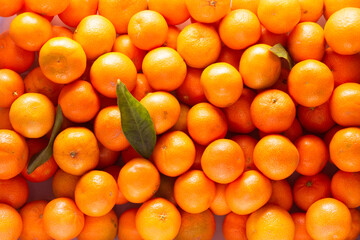 many tangerines in a box with leaves