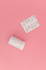 Pills on pink background