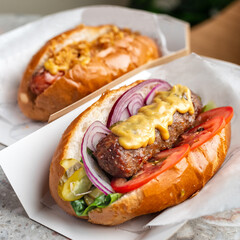 Close up of hot dog. Fast food. Diagonal composition. It lies on a black slate.