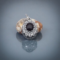 silver pendant от a stone on gray background with reflection, close-up