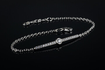 silver bracelet with diamonds on black background.