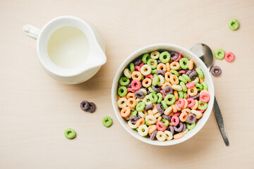 Bowl of colorful corn rings with milk.