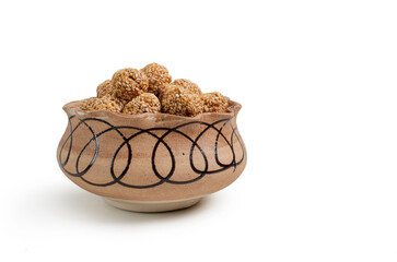 happy makar sankranti special Sesame seed ball called Till ke laddu in bowl isolated on white background