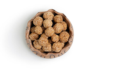 happy makar sankranti special Sesame seed ball called Till ke laddu in bowl isolated on white...