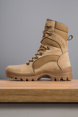 Khaki high military boots on a gray background