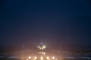 passenger plane takes off at night, airfield lights