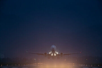 passenger plane takes off at night, airfield lights