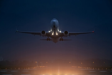 passenger plane takes off at night, airfield lights