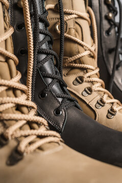 Khaki and black tall military boots on a gray background
