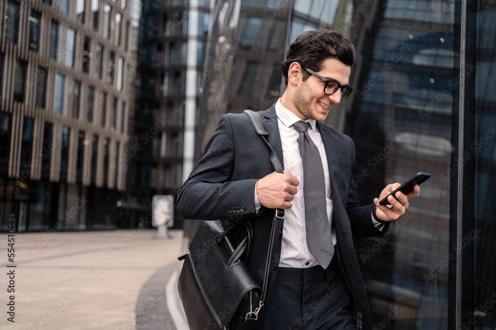 Wall mural phone message a manager with glasses goes to work in the office in a business suit, smiles and think