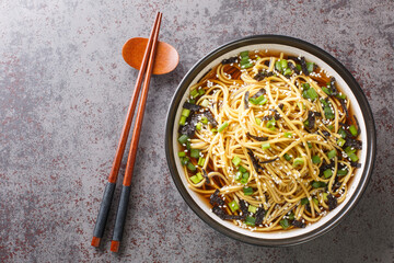 Memil guksu is a traditional Korean soba noodle soup boiled in a broth made from guksijangguk and Japanese hondashi closeup in the bowl on the table. Horizontal top view from above