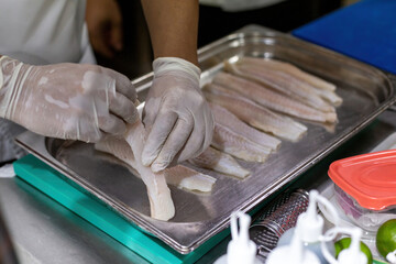 Cook arranging fish on a tray