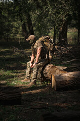 A military soldier in a special uniform with a tactical backpack in the forest
