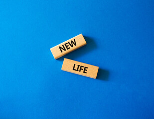 New life symbol. Wooden blocks with words New life. Beautiful blue background. Business and New life concept. Copy space.