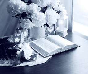 Still life. Open book and bouquet of flowers