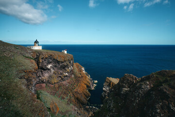 The Scottish seashore and the lighthouse on the cliff. St Abb's Head National Nature Reserve on the Berwickshire coastline, Scotland, UK