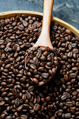 Fototapeta premium Dark roasted coffee beans with wooden scoop 