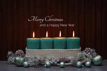 Christmas card: Green burning candles with Christmas decorations and fir branches. With the text Merry Christmas and a Happy New Year
