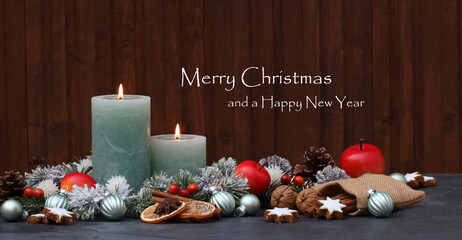 Christmas card: Green burning candles with Christmas decorations and fir branches. With the text Merry Christmas and a Happy New Year