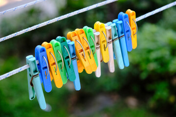 Colored clothespins on a clothesline on a green background