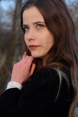 Young girl in black elegance wear walk in the winter forest. Sunset and snow	