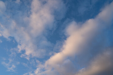Naklejka na ściany i meble Blue sky with white smoky clouds on a spring evening