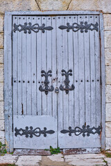 Antique wooden painted doors with a metal handle and forged decorative inserts