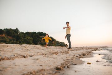 Dad and child 2-3 years old on a sandy beach child runs away from dad
