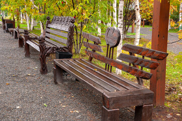 City brown wooden bench on the street in the autumn park