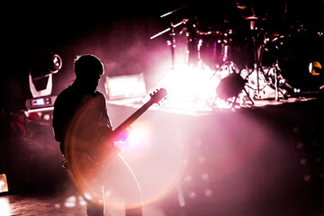 Silhouette of guitarist musician on stage at a concert. 