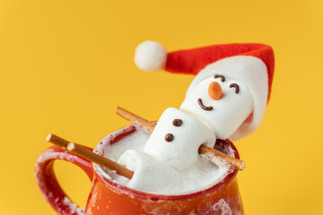 Marshmallow snowman taking hot tub in a red ceramic cup full of cocoa with milk foam. Christmas...