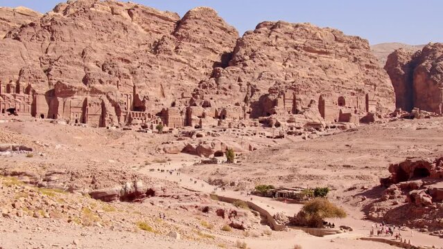 Group of tourist sightseeing walk in famous ancient city of Petra, Jordan. It is know as the Loculi. Petra has led to its designation as UNESCO World Heritage Site.
