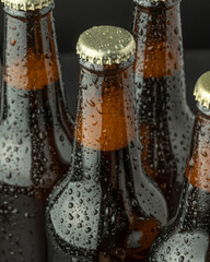 Cold beer in a brown bottle with large water drops on the glass surface. Dark craft beer