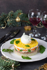 Festive salad Mimosa for the New Year with canned tuna, potatoes and carrots, decorated bunny from egg