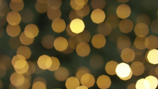 Camera tilts up on blurred background of Christmas lights on a tree, great for background