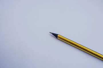 Gold color pencil on a white background. exam, study, student and school concept.