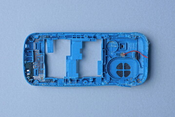 one blue plastic case of an old mobile phone lies on a gray table