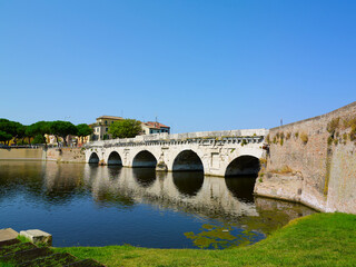 Tiberius bridge in Rimini on a background of blue sky