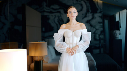Morning of a bride. Action. Beautiful bride in a hotel room in a wedding dress standing in a...