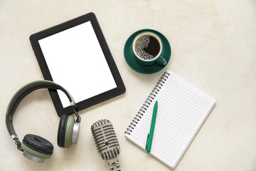 Notebook with tablet computer, headphones, microphone and coffee cup on white background. Podcast concept